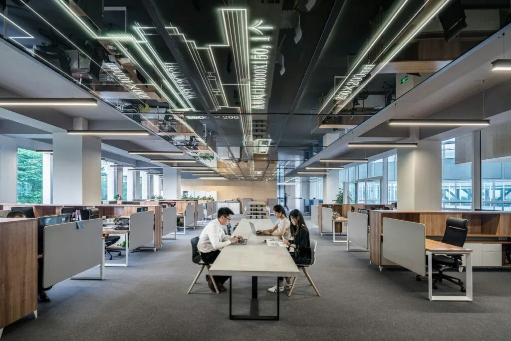 lycs-architecture-U2BI3GMnSSE-unsplash office with workers working on laptops on a big table